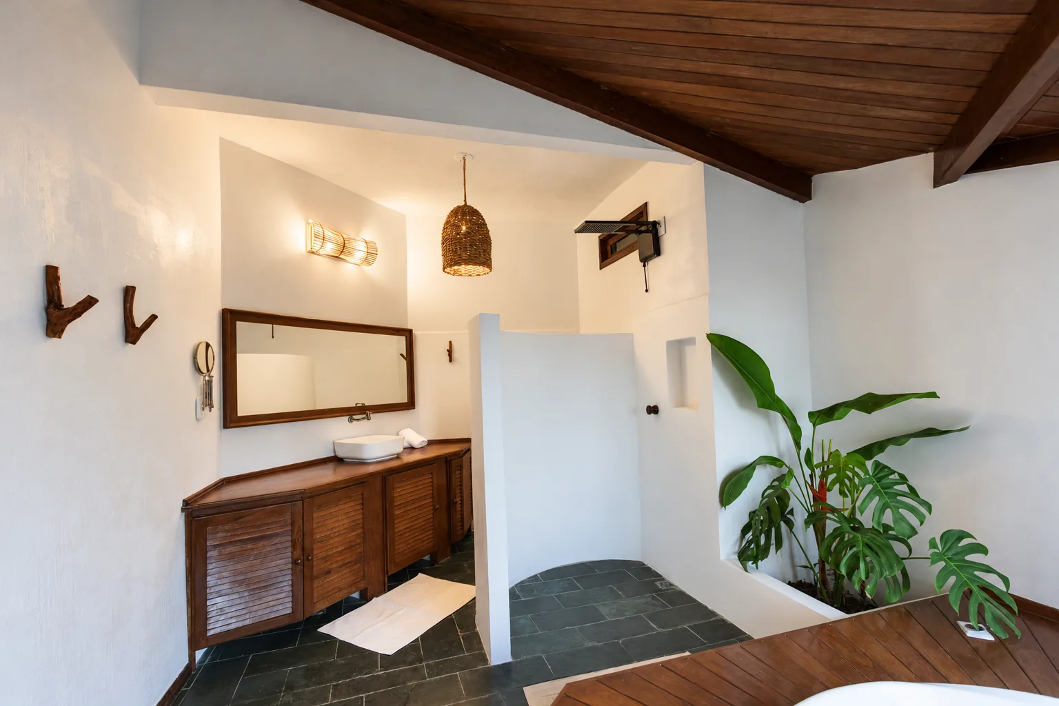 Salle de bain de la Suite Vue Mer de l’Azorai avec plan en bois, sol en ardoise et plantes