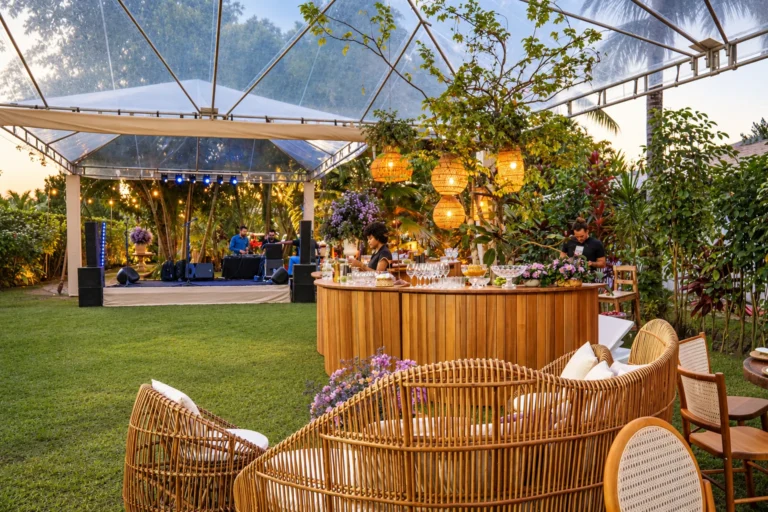 Bar de madeira e lounge com poltronas de palha no jardim, em festa de casamento no Azorai