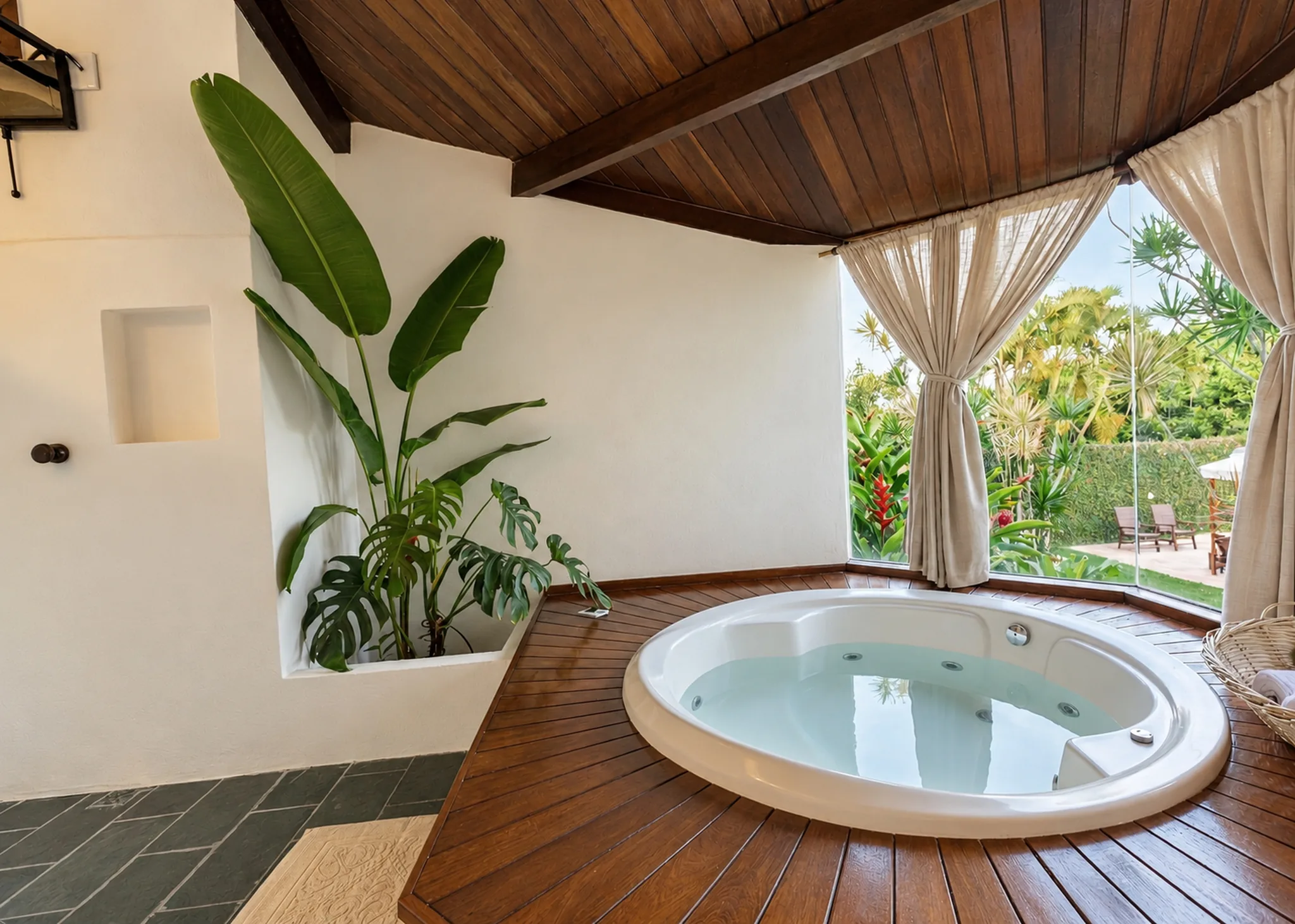 Jacuzzi sur un deck en bois, entre les plantes tropicales, dans la Suite Vue Mer de l’Azorai