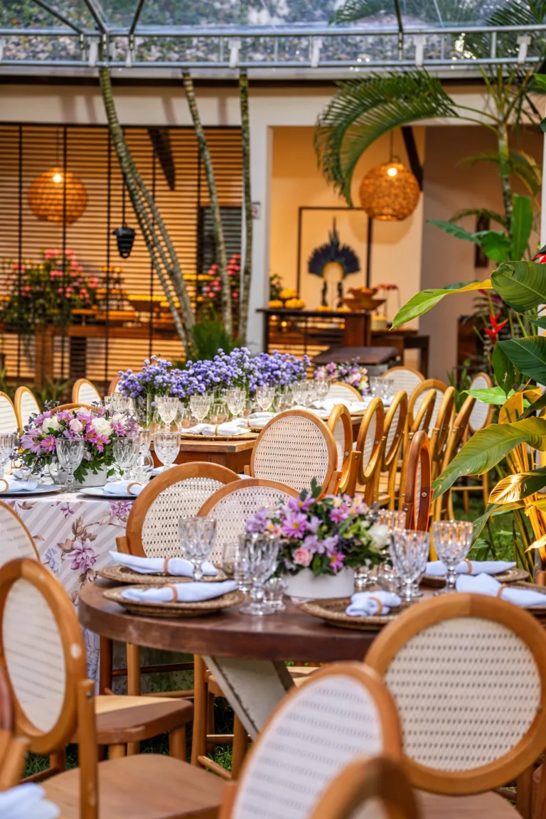 Mesas redondas decoradas com flores e cadeiras de palhinha na recepção de casamento no Azorai
