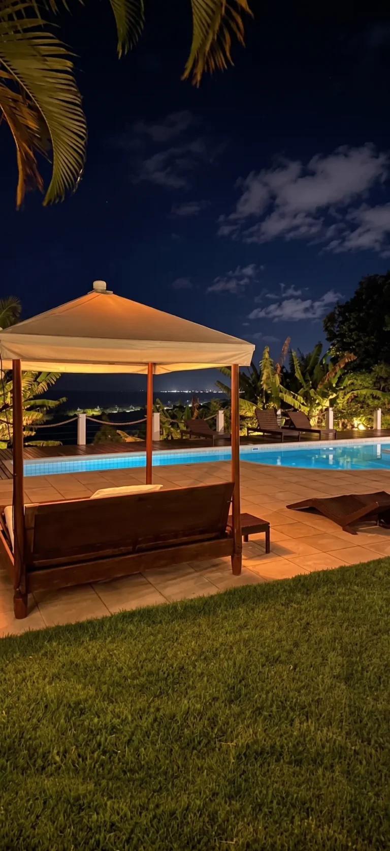Piscina iluminada de noche con cabaña en Azorai, hotel boutique con vista al mar en Bahía