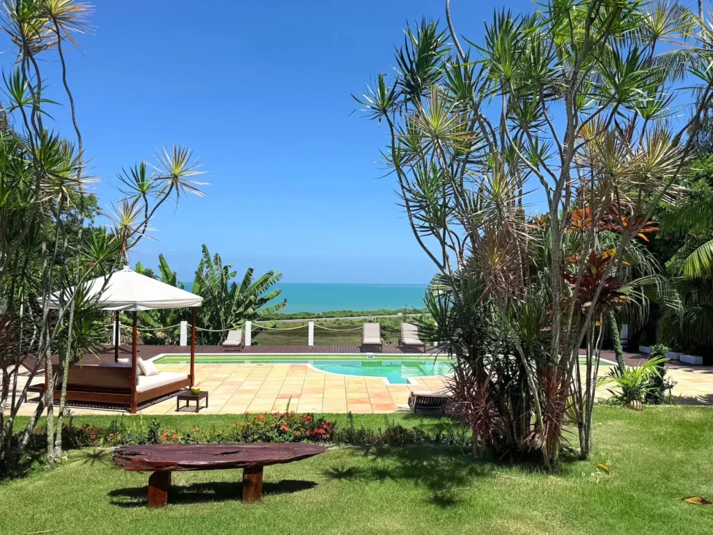 Piscina do Azorai com vista para o mar e jardim tropical em Santa Cruz Cabrália