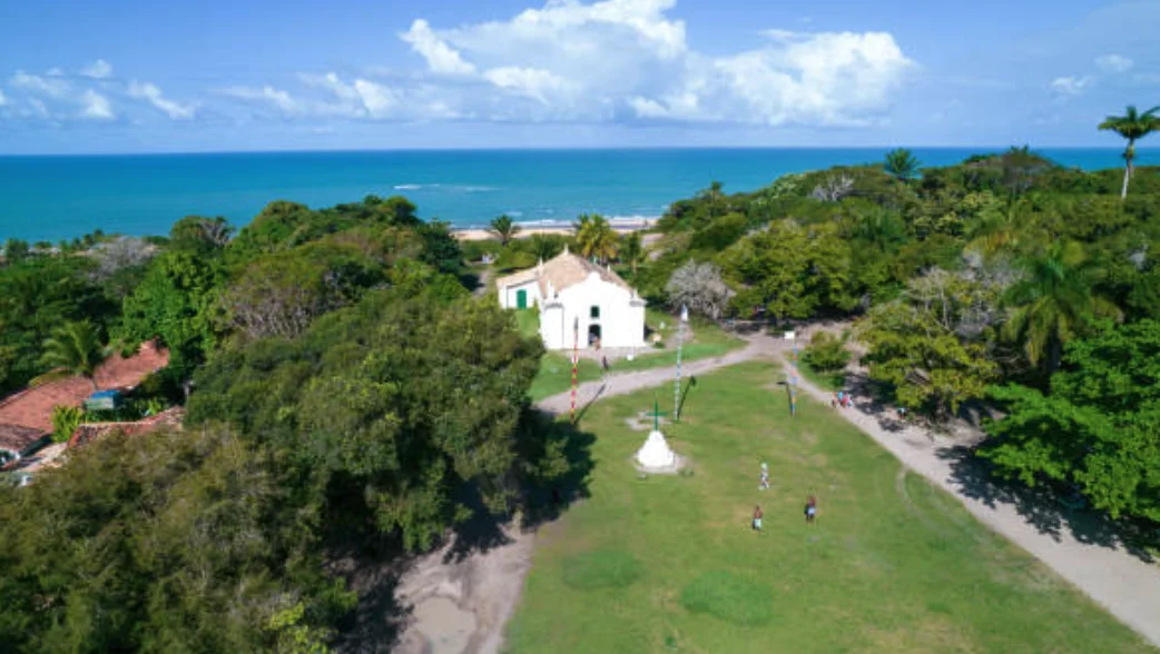Vista aérea del Quadrado de Trancoso con la Iglesia de São João Batista y el mar al fondo, en Bahía