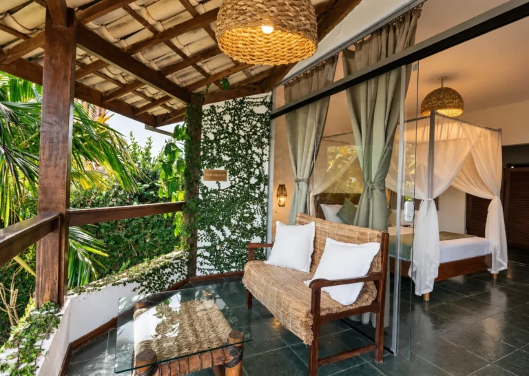 Private balcony of Azorai's Sea View Suite with wicker armchairs and tropical garden